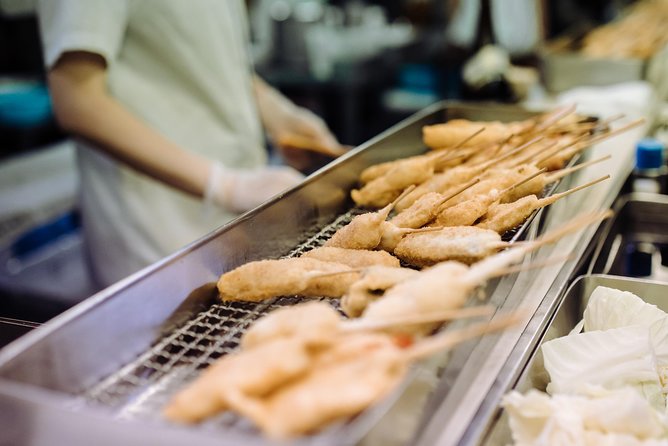 Osaka Private Food Tours by Local Foodies: 100% Personalized - Walking through an arcade for sweets and skewers